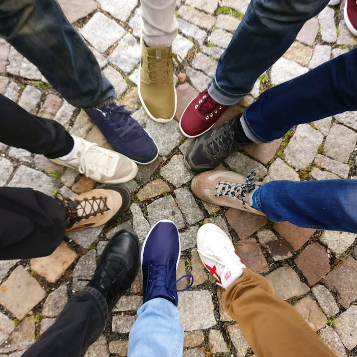 Mastering the First Impression: Your intriguing post title goes here Circle of sneakers on cobblestone pavement representing diversity and urban fashion.